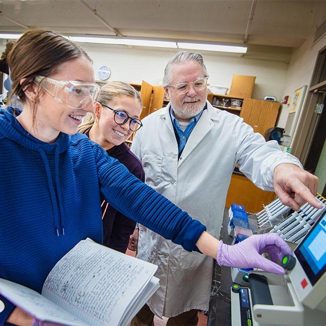 Dr. Peliska working with student in a science lab.